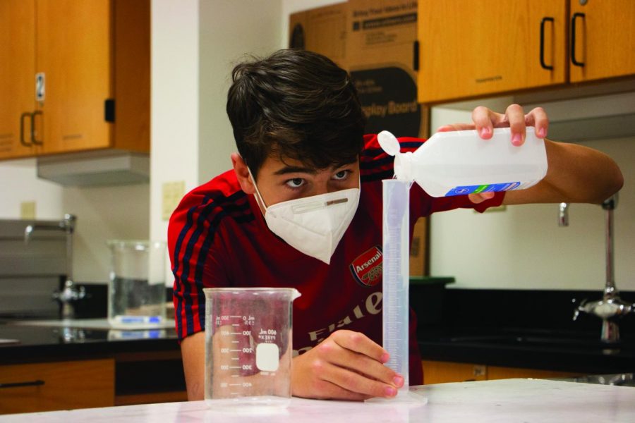 Pol Berger Romeu, STEM Research Club member and junior, measures ethanol using a graduated cylinder at a STEM Research Club meeting on Oct. 8. Berger Romeu said experimenting has allowed him to explore his interests and has made him a more driven and resilient person.