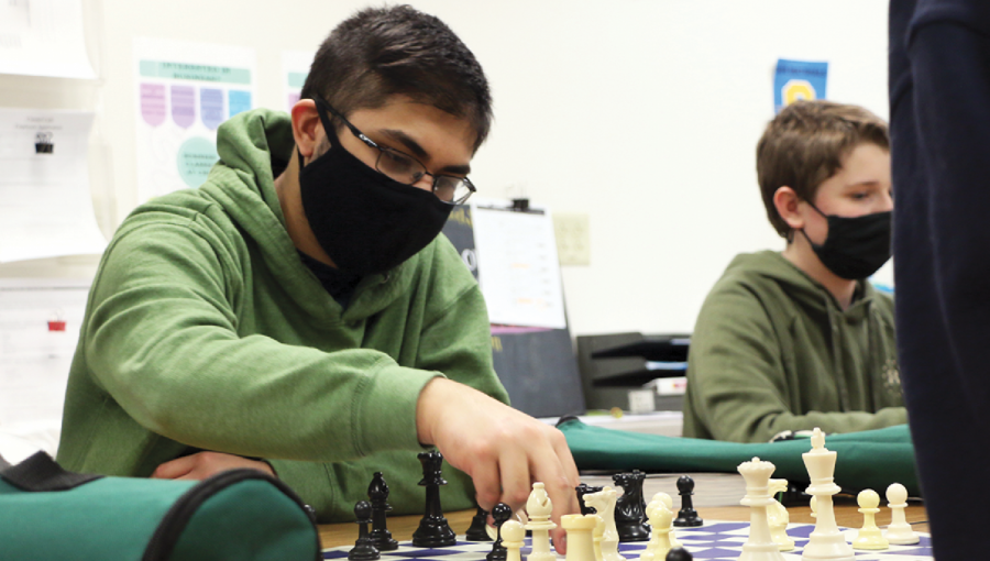MAKE A MOVE
Akash “Reno” Bhowmik, Chess Club co-president and junior, picks up a chess piece to make a move against his opponent during the Feb. 24 meeting in F108. Bhowmik said he values the friendships he is able to enhance through Chess Club meetings.