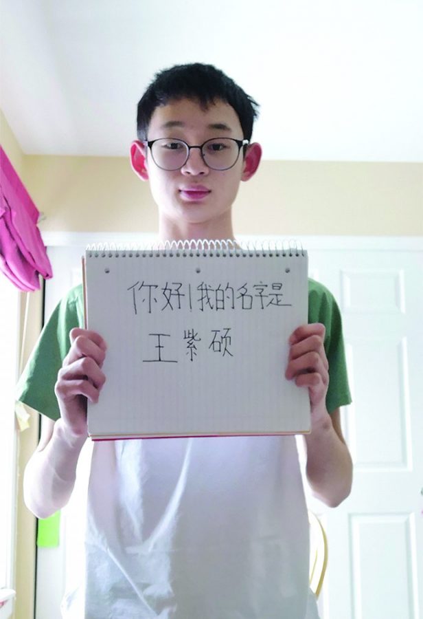 Tsion Daniel
Sophomore Zishuo Wang poses with a sign that says “Hi! My name is Zishuo” in his first language, Chinese. Wang said, “When you speak a different language than English, it is kind of difficult because the environment of learning English is not there where I lived.”
