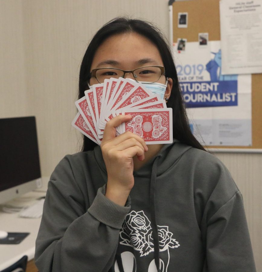 Photo || Karolena Zhou
Junior Grace Zhu holds cards up to her face, contemplating her next move. Zhu said that she is very competitive: “I like to win.”