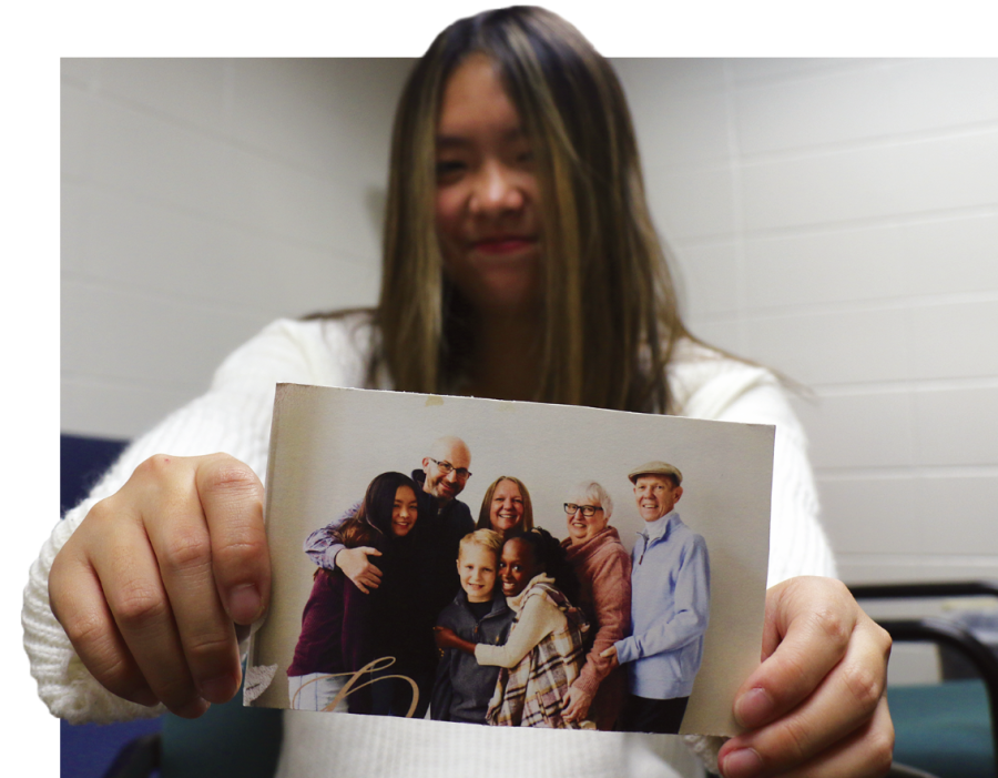 Junior Jasmine McCarty holds up a picture of her adoptive family. She said adoption is a good process she thinks more people should look into. “There (are) so many people out there that are waiting for people to take them in,” she said