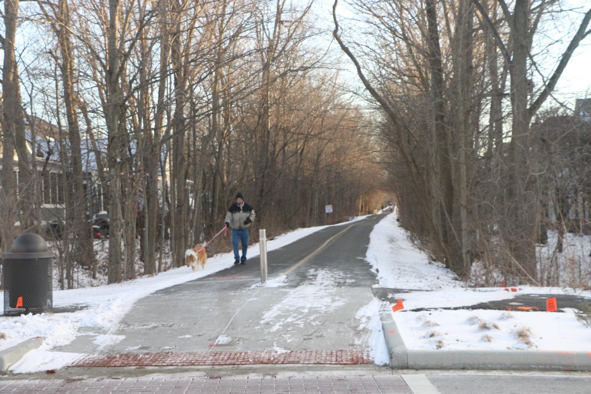 A man walking his dog on the Monon Trail. The upkeep of the Monon Trail represents one oft he initiatives that Carmel takes to promote conservation.