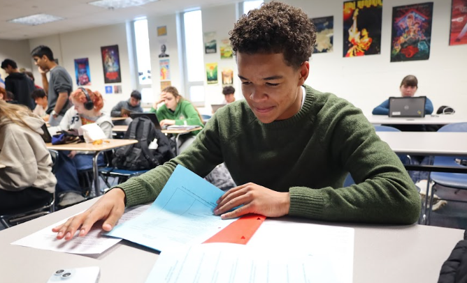 Senior Johan Mwilambwe works on homework during one of his classes. Mwilambwe said there is too much academic pressure on students nowadays.